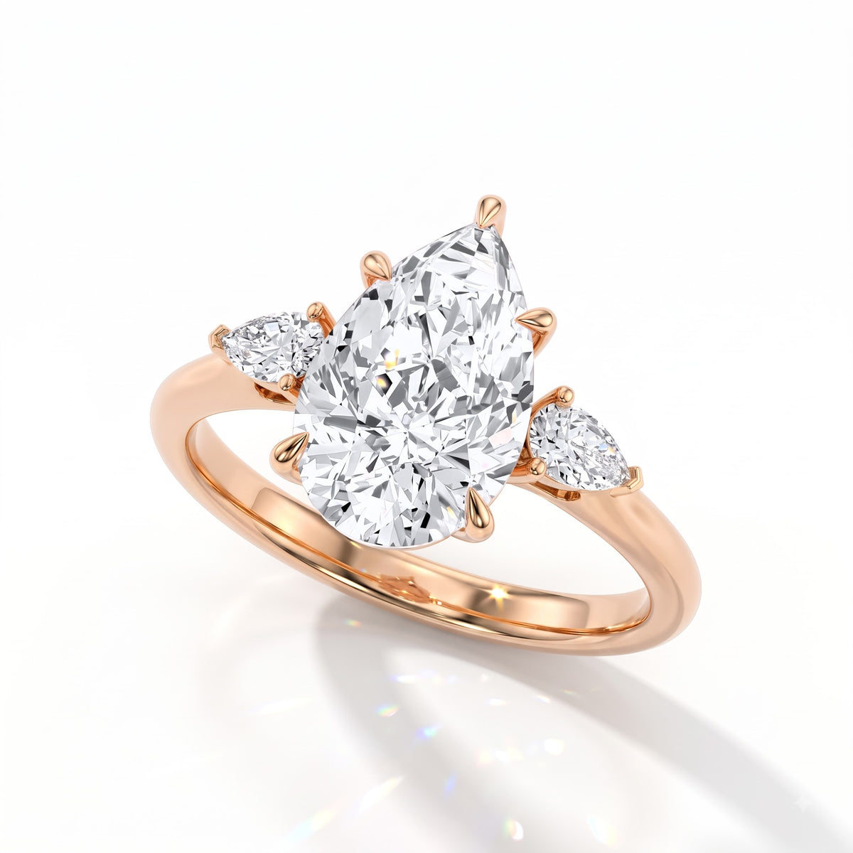 Pear cut lab-grown diamond three-stone engagement ring with pear side stones in 14K (585) rose gold, angled view