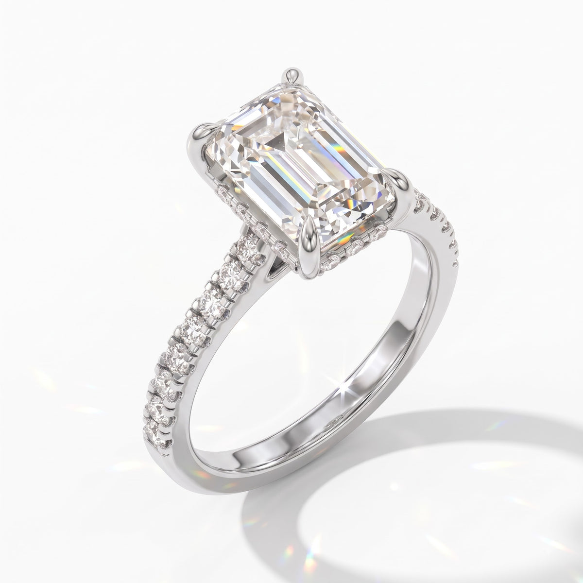Emerald cut lab-grown diamond hidden halo engagement ring with pavé band in 950 platinum, angled view