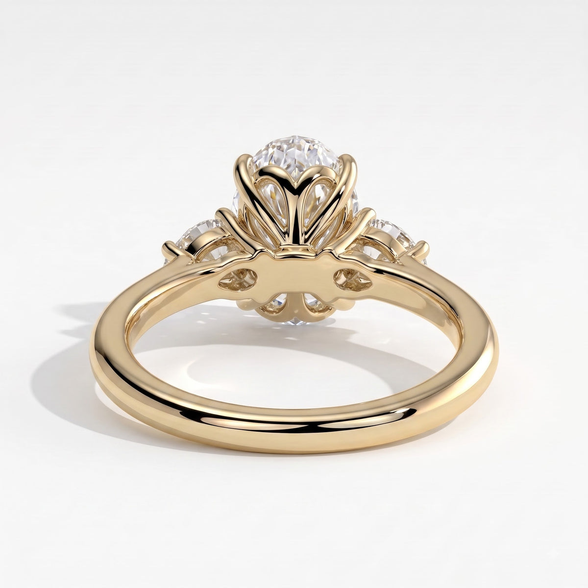 Oval lab-grown diamond three-stone engagement ring in 14K (585) yellow gold, on white background