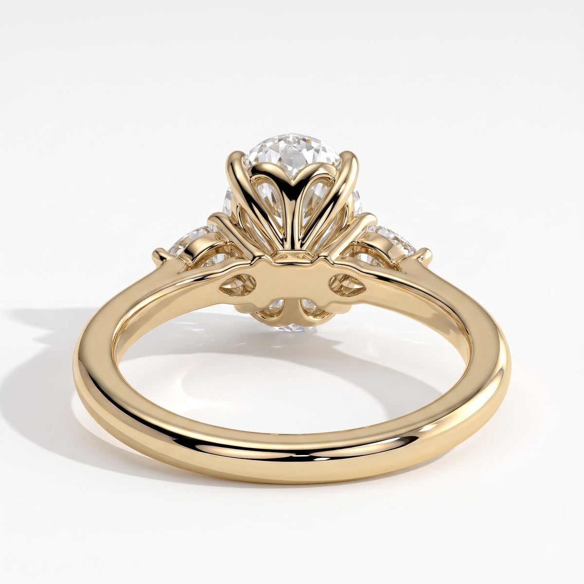 Oval lab-grown diamond three-stone engagement ring in 18K (750) yellow gold, on white background