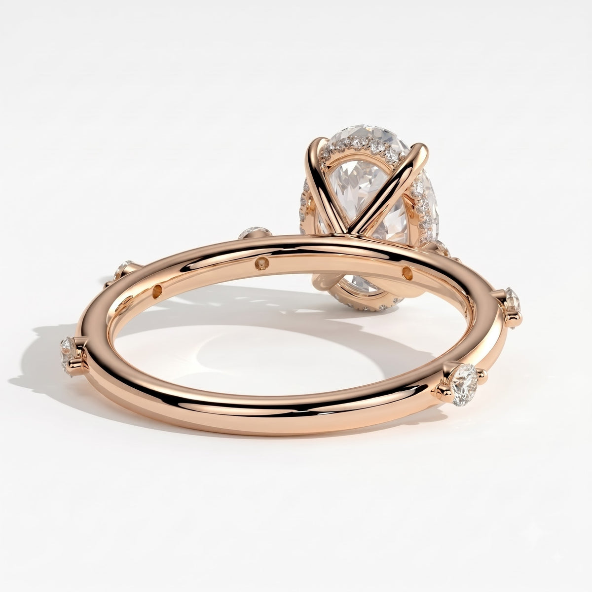 Oval lab-grown diamond halo engagement ring in 18K (750) rose gold, on white background