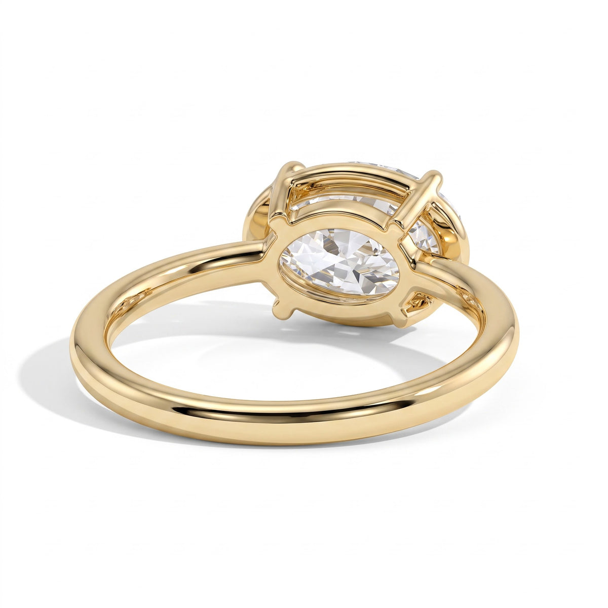 Oval lab-grown diamond bezel-set east-west solitaire engagement ring in 18K (750) yellow gold, on white background