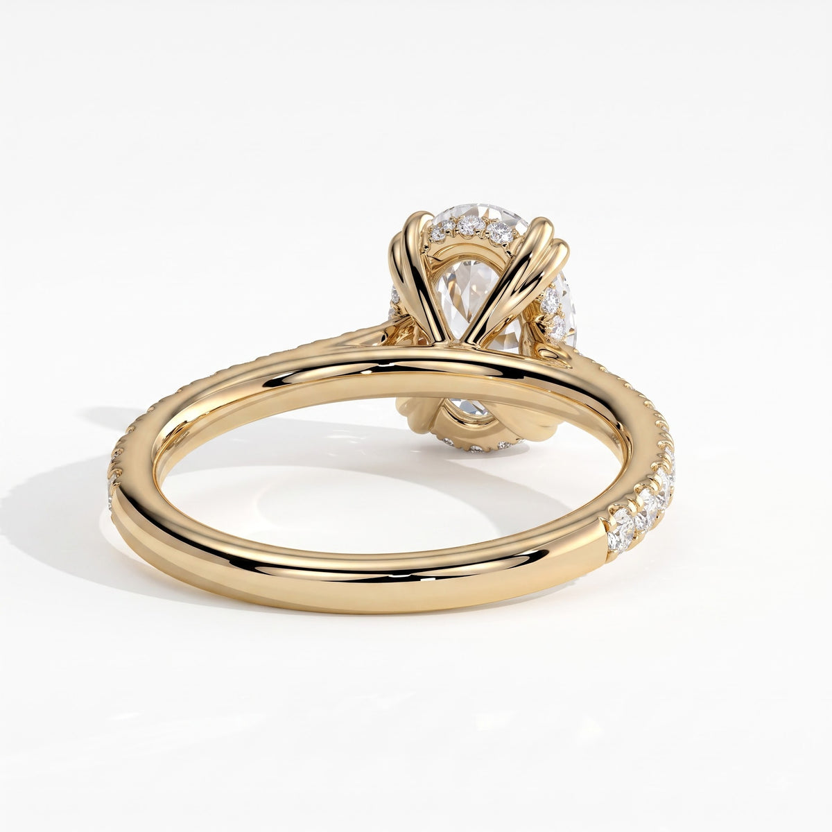 Oval lab-grown diamond halo engagement ring in 14K (585) yellow gold, on white background