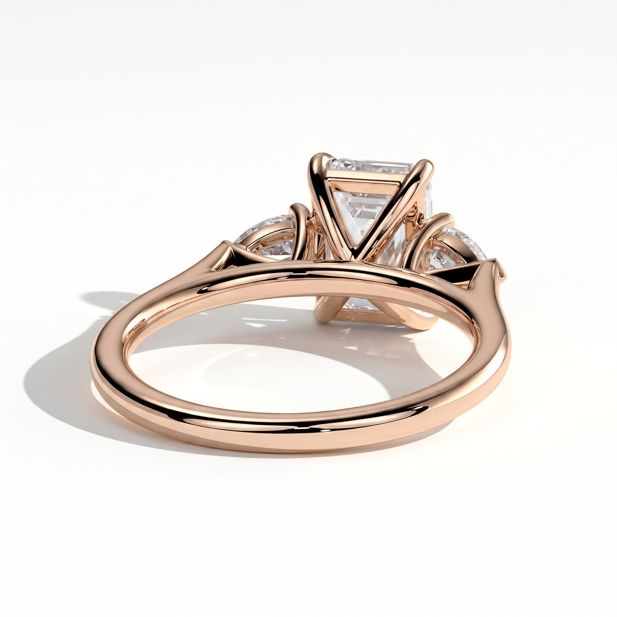 Emerald lab-grown diamond three-stone engagement ring in 14K (585) rose gold, on white background