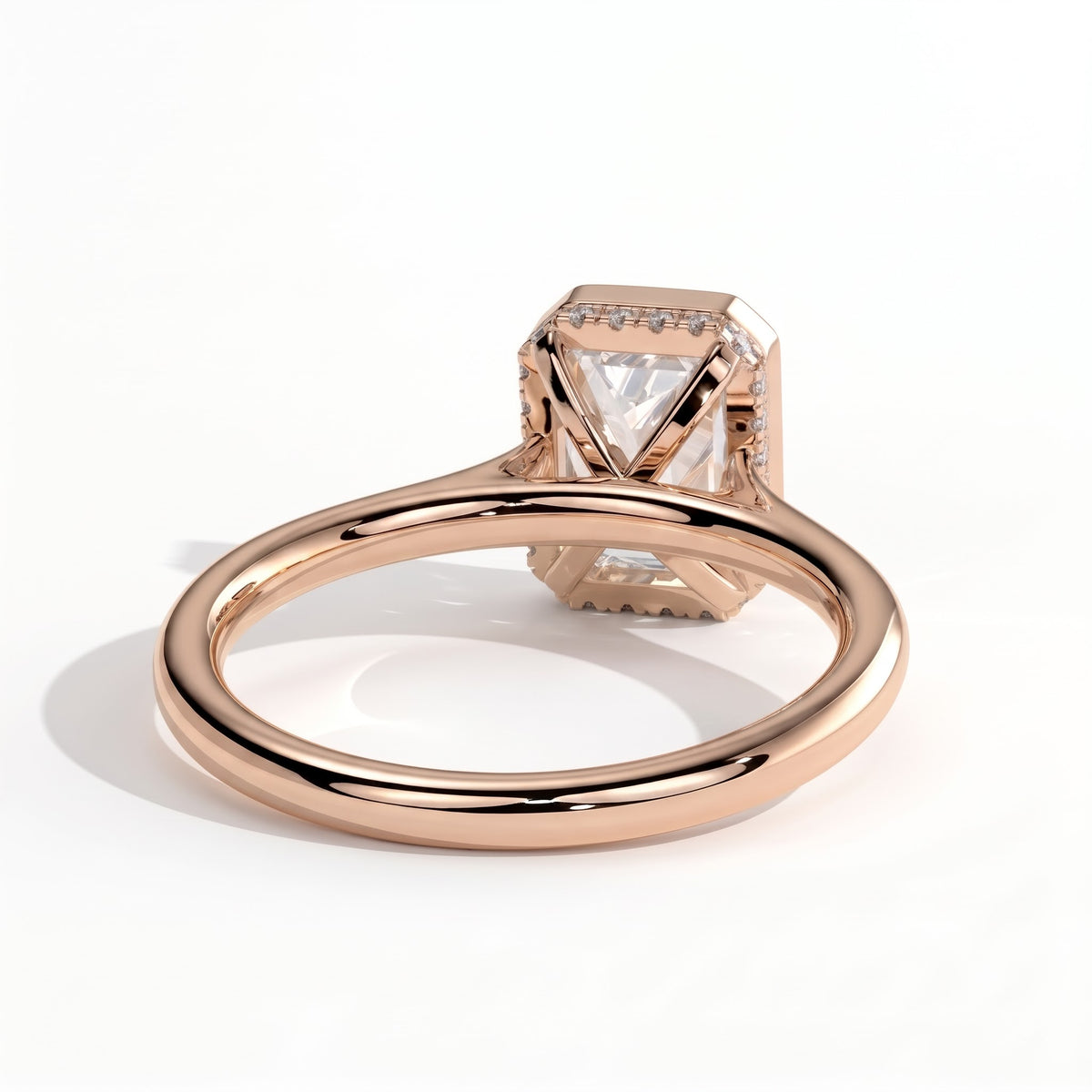 Emerald lab-grown diamond bezel-set halo engagement ring in 14K (585) rose gold, on white background
