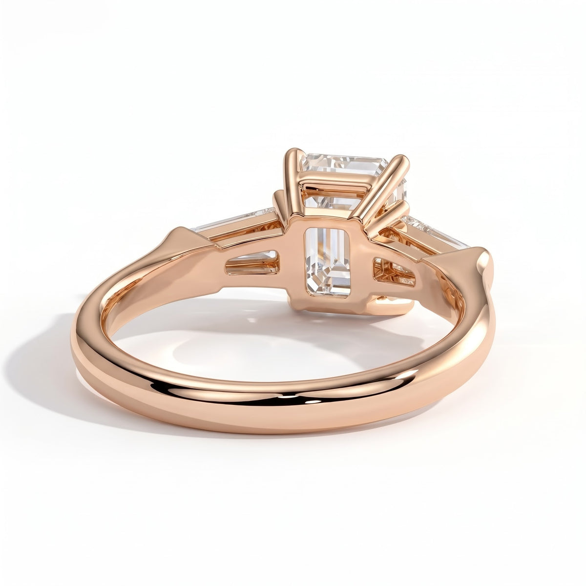 Emerald lab-grown diamond three-stone engagement ring in 18K (750) rose gold, on white background