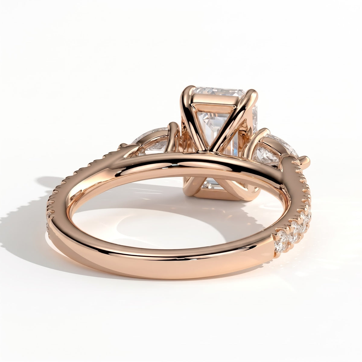 Emerald lab-grown diamond three-stone engagement ring in 18K (750) rose gold, on white background