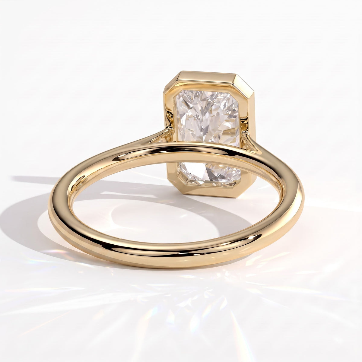 Radiant lab-grown diamond bezel-set solitaire engagement ring in 14K (585) yellow gold, on white background