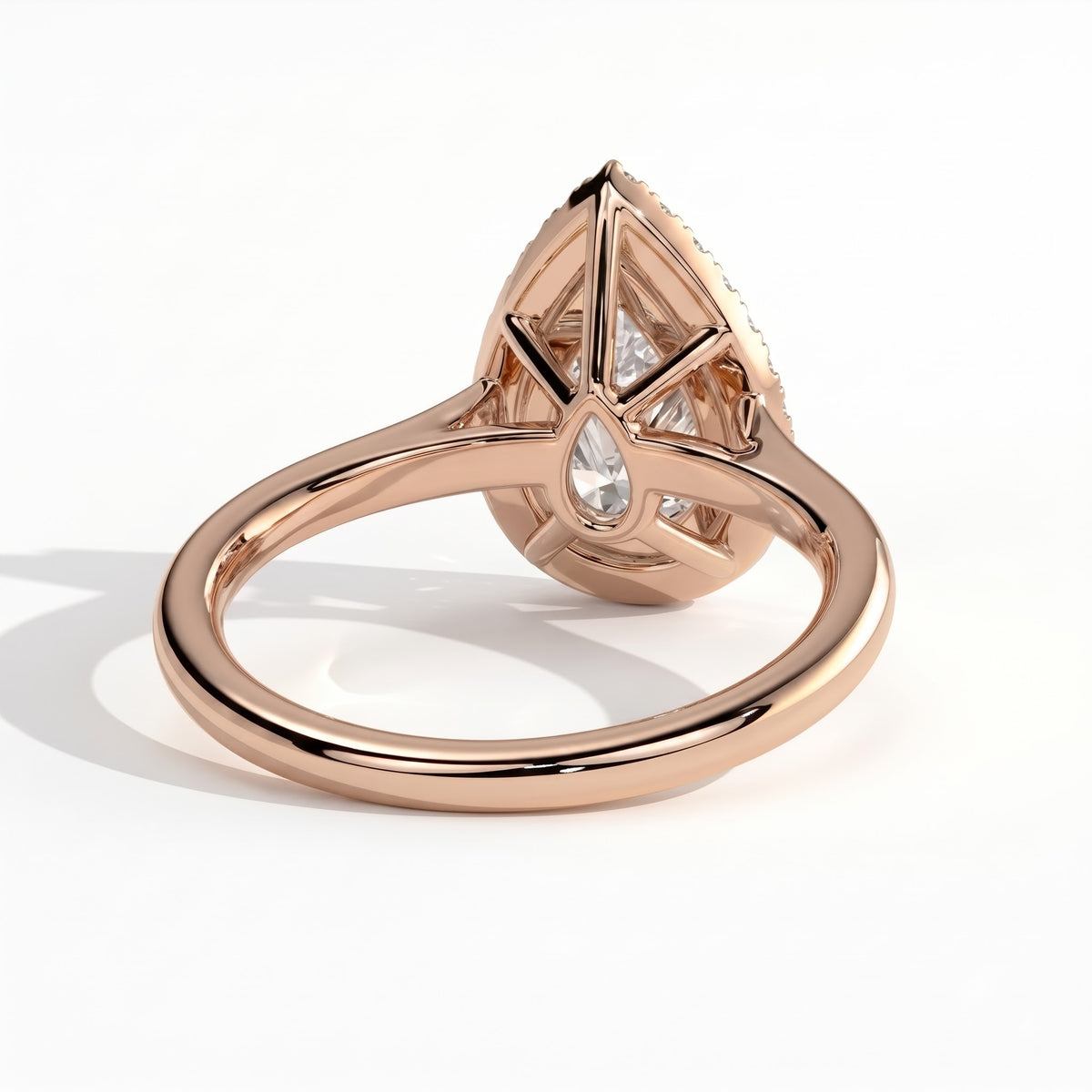 Pear lab-grown diamond halo engagement ring in 18K (750) rose gold, on white background