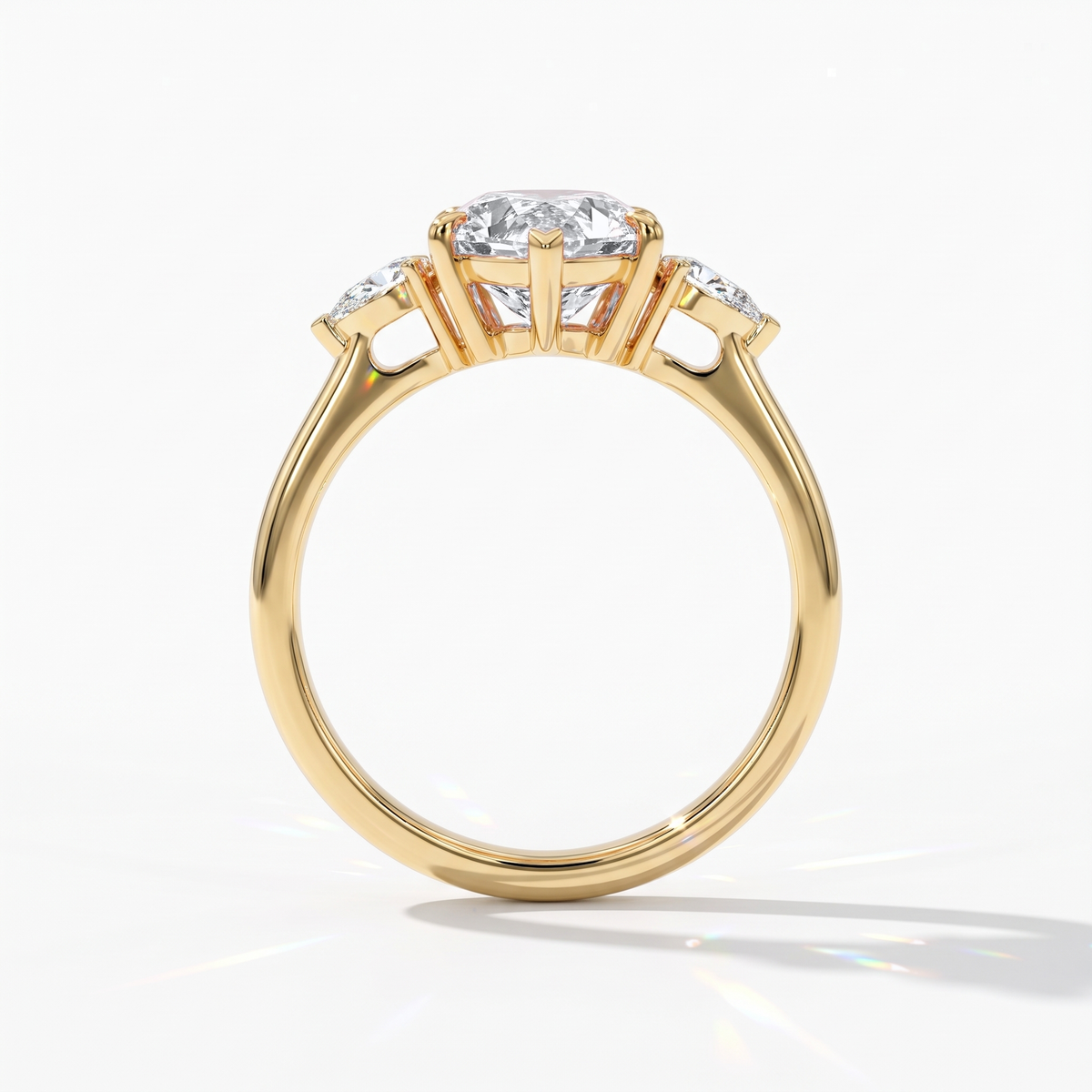 Pear cut lab-grown diamond three-stone engagement ring with pear side stones in 14K (585) yellow gold, upright profile view