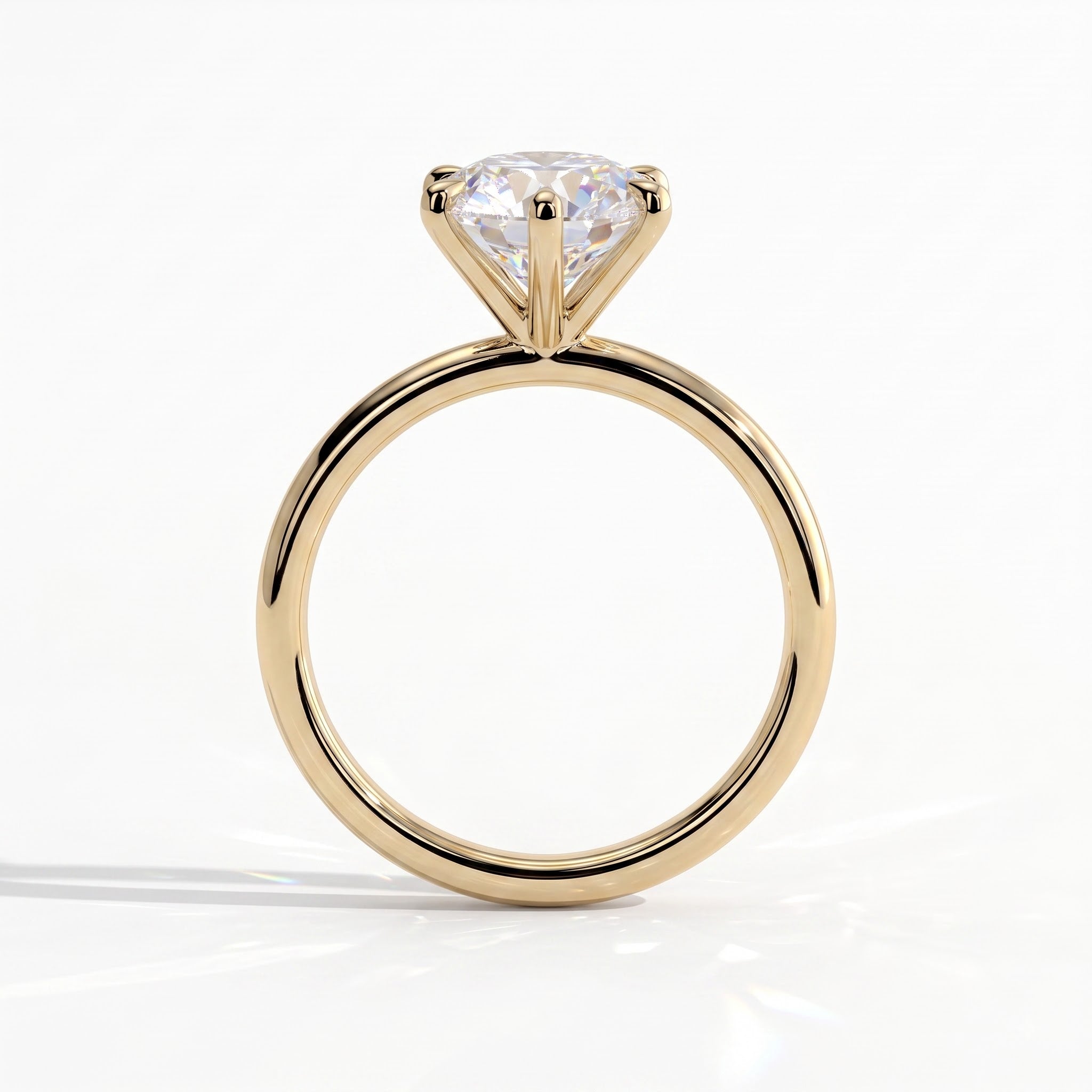 A yellow gold solitaire engagement ring with a round brilliant-cut diamond, shown from a side profile view on a clean white background.