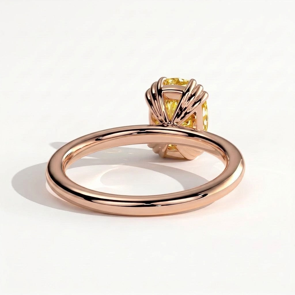 Fancy Vivid Yellow elongated cushion lab-grown diamond solitaire engagement ring with triple claw prongs in 14K (585) rose gold, detail view of the triple claws