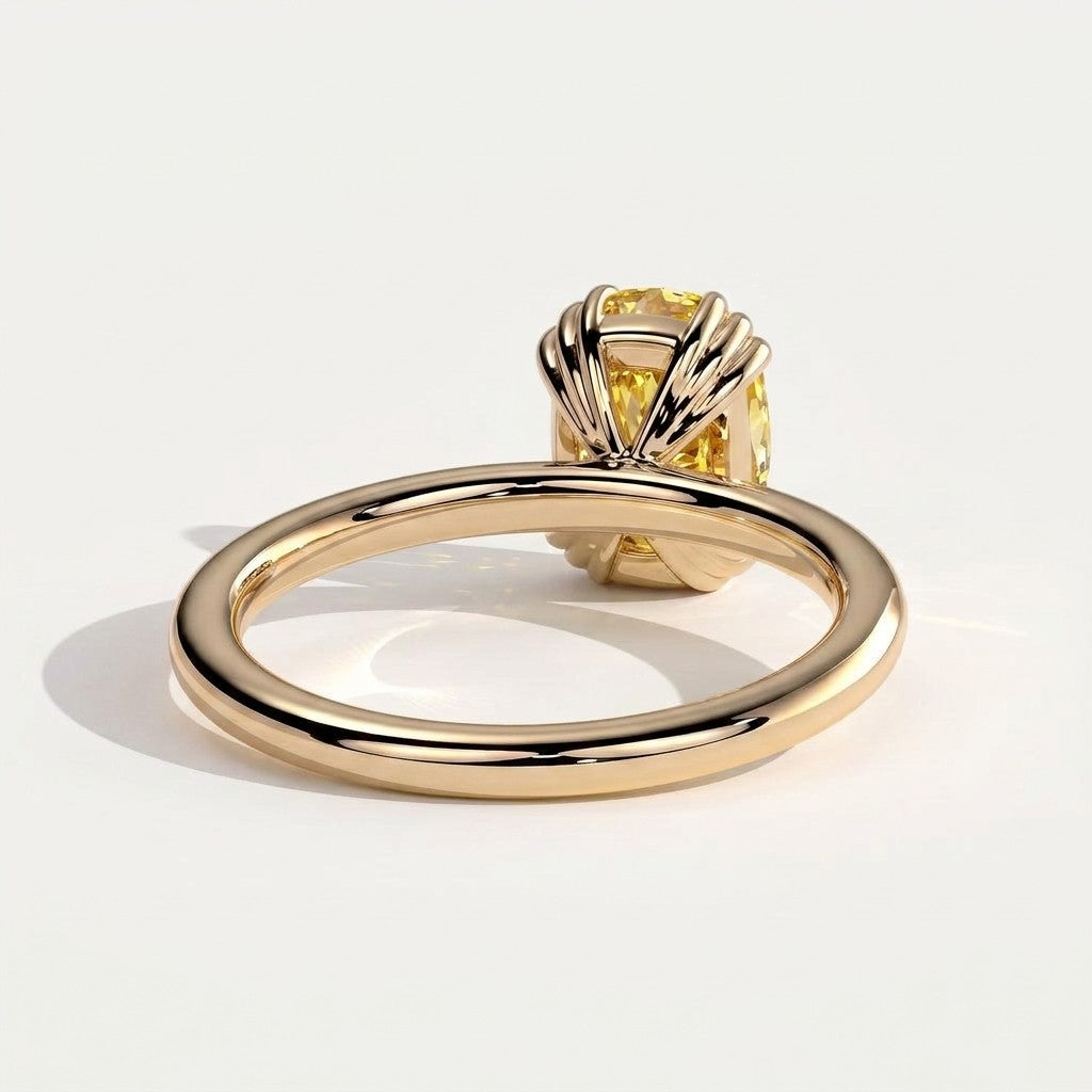 Fancy Vivid Yellow elongated cushion lab-grown diamond solitaire engagement ring with triple claw prongs in 14K (585) yellow gold, on white background