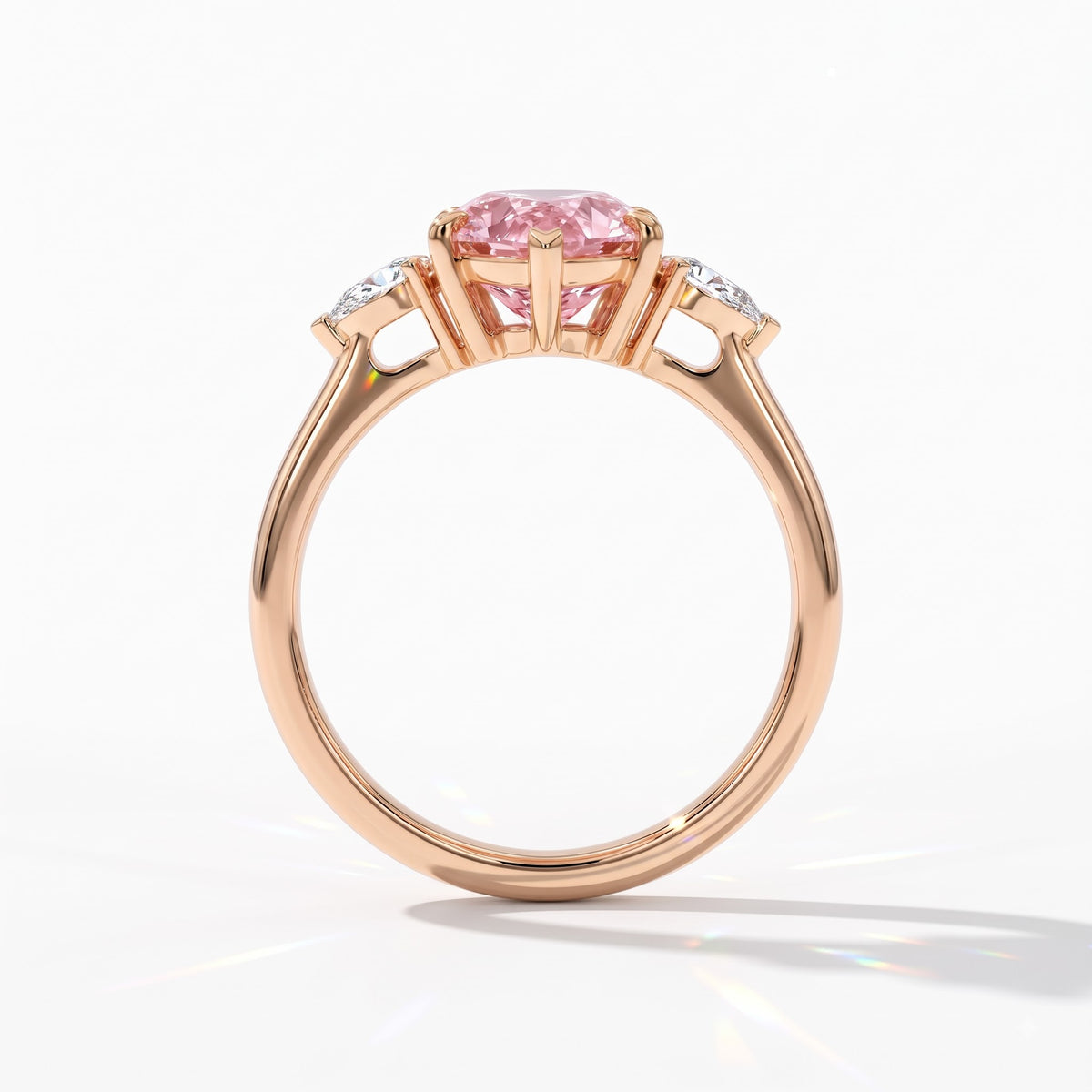 Fancy Vivid Pink pear cut lab-grown diamond three-stone ring with pear side diamonds in 14K (585) rose gold, upright profile view 