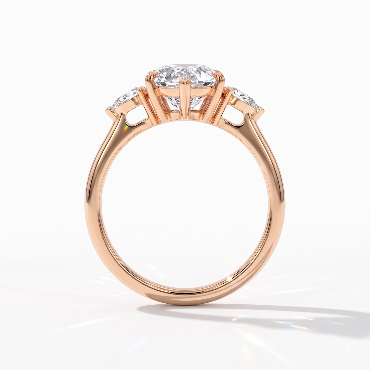 Pear cut lab-grown diamond three-stone engagement ring with pear side stones in 14K (585) rose gold, upright profile view 