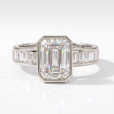 Emerald cut lab-grown diamond bezel engagement ring with channel-set baguette diamonds in 14K (585) white gold, front view 