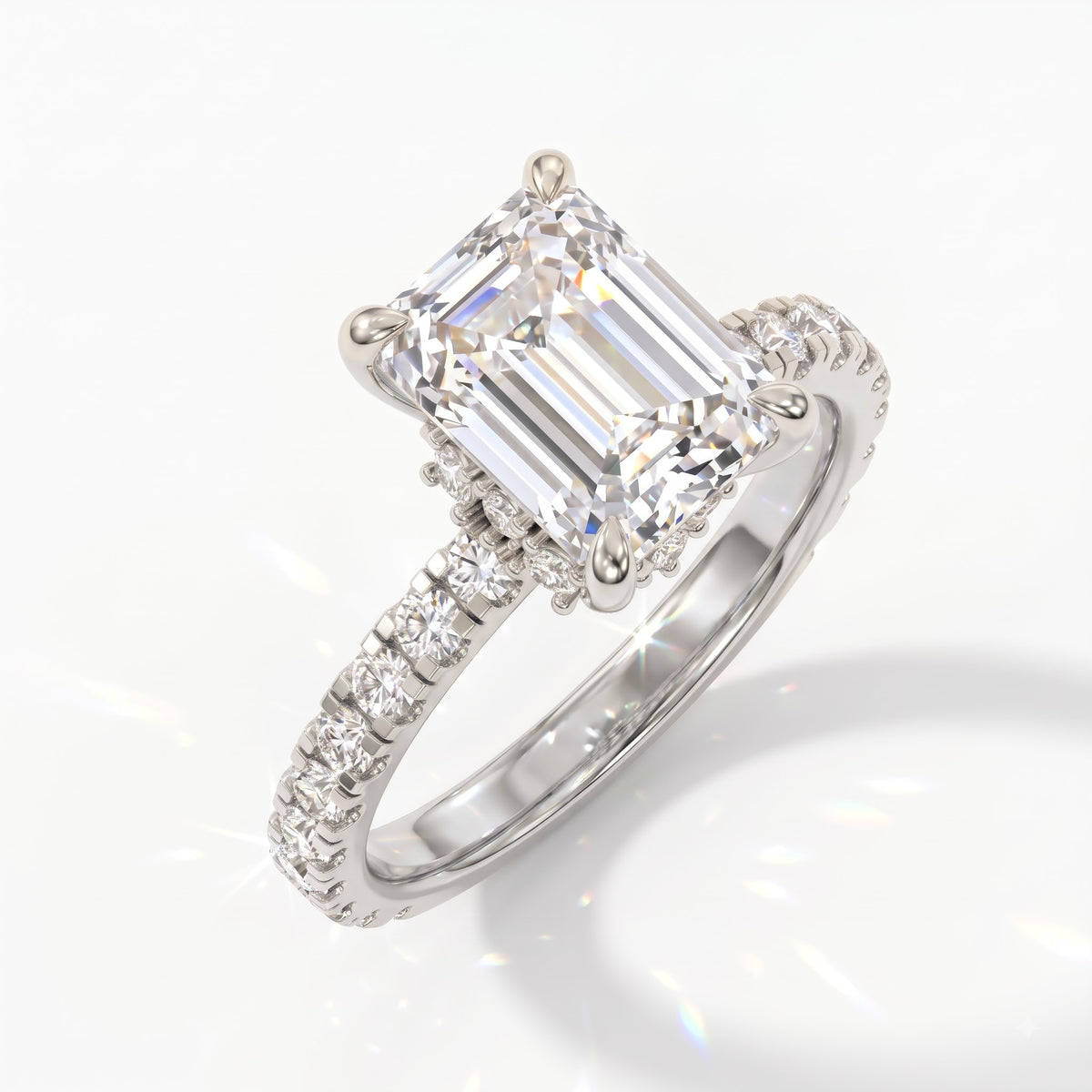 Emerald cut lab-grown diamond hidden halo collar engagement ring with pavé band in 950 platinum, angled view 