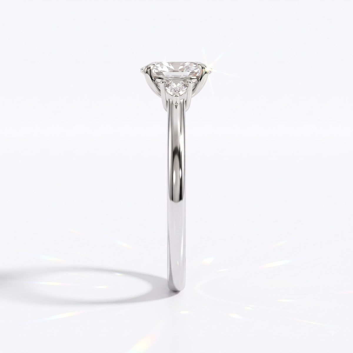 Oval cut lab-grown diamond three-stone engagement ring with pear side stones in 18K (750) white gold, side view 