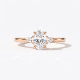 Oval cut lab-grown diamond three-stone engagement ring with pear side stones in 18K (750) rose gold, front view 
