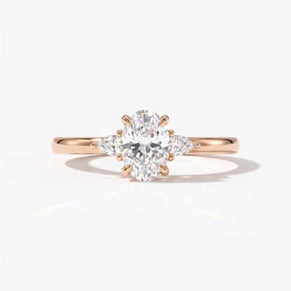 Oval cut lab-grown diamond three-stone engagement ring with pear side stones in 18K (750) rose gold, front view 