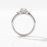 Oval cut lab-grown diamond three-stone engagement ring with pear side stones in 18K (750) white gold, upright profile view 