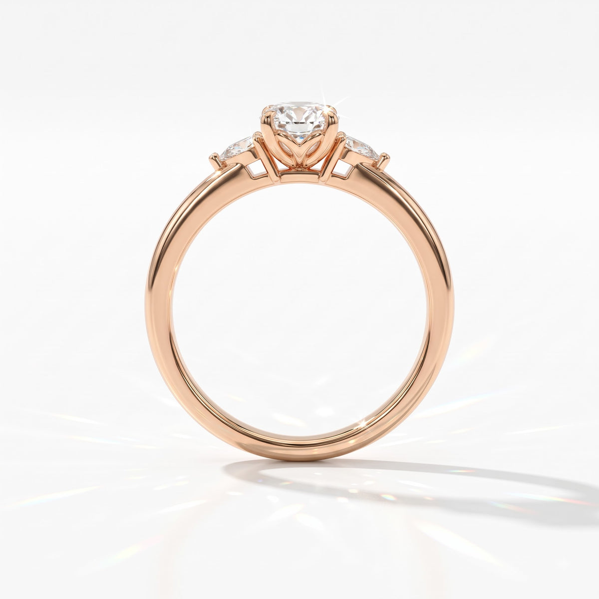 Oval cut lab-grown diamond three-stone engagement ring with pear side stones in 18K (750) rose gold, upright profile view 