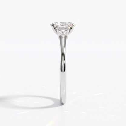 Oval cut lab-grown diamond three-stone engagement ring with pear side stones in 950 platinum, side view 