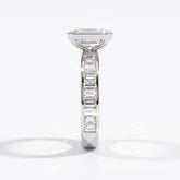 Emerald cut lab-grown diamond bezel engagement ring with channel-set baguette diamonds in 18K (750) white gold, side view 