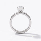 Emerald cut lab-grown diamond bezel engagement ring with channel-set baguette diamonds in 950 platinum, upright profile view 