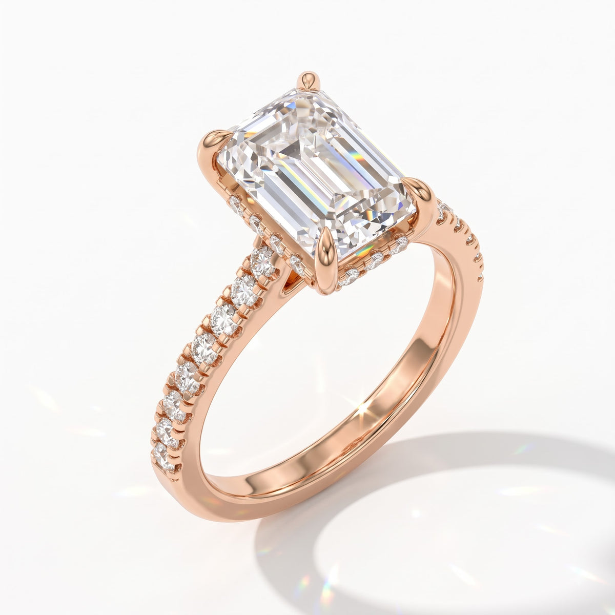 Emerald cut lab-grown diamond hidden halo engagement ring with pavé band in 18K (750) rose gold, angled view 