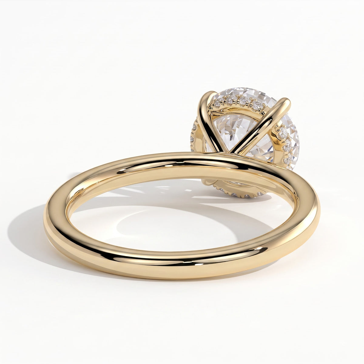 Round lab-grown diamond solitaire engagement ring in 18K (750) yellow gold, on white background 