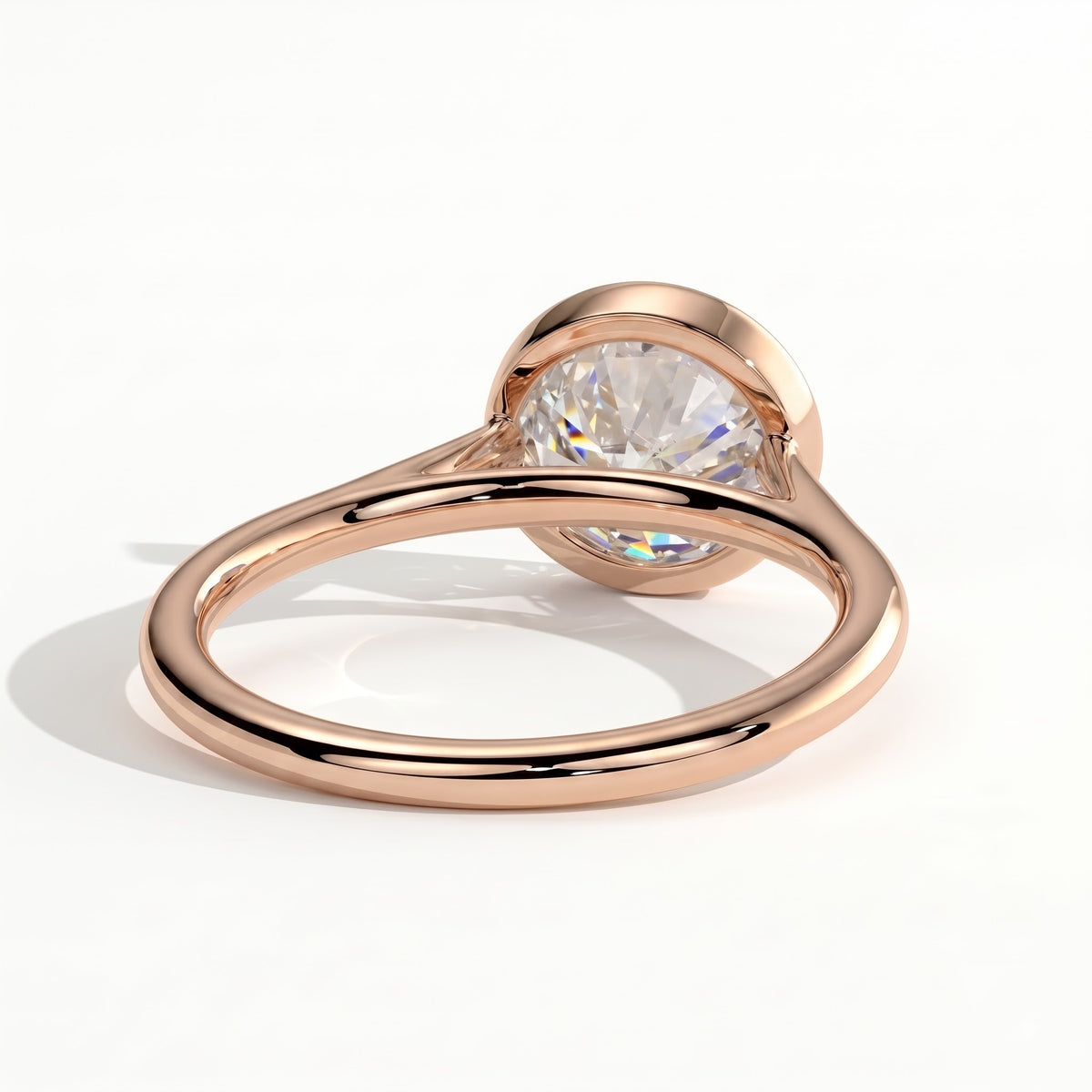 Round lab-grown diamond bezel-set solitaire engagement ring in 14K (585) rose gold, on white background 