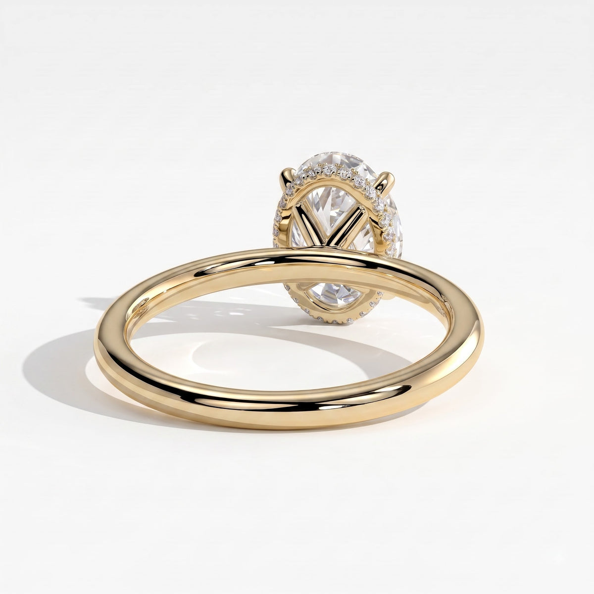 Oval lab-grown diamond solitaire engagement ring in 18K (750) yellow gold, on white background 