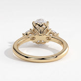 Oval lab-grown diamond three-stone engagement ring in 14K (585) yellow gold, on white background 