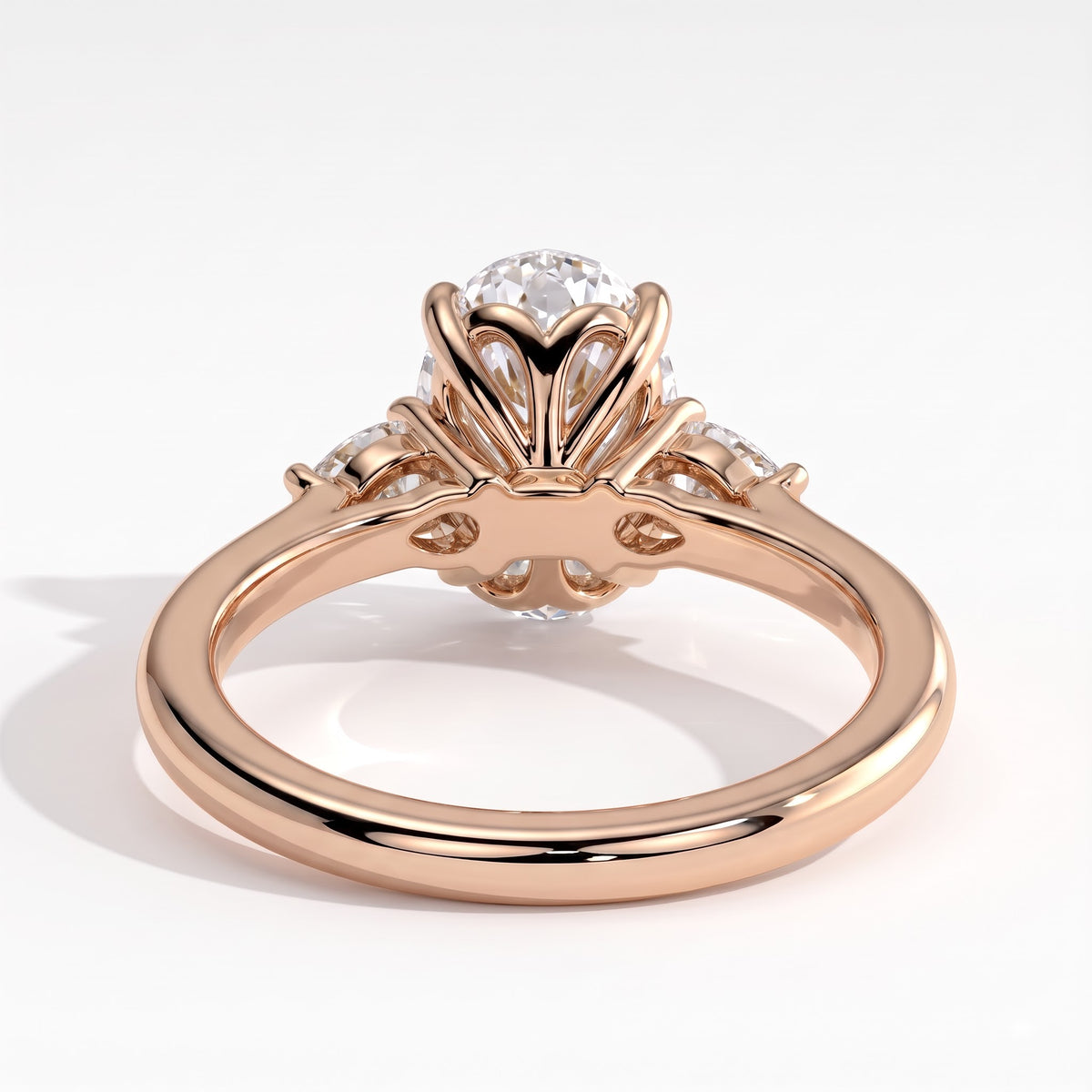 Oval lab-grown diamond three-stone engagement ring in 14K (585) rose gold, on white background 