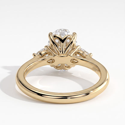 Oval lab-grown diamond three-stone engagement ring in 18K (750) yellow gold, on white background 