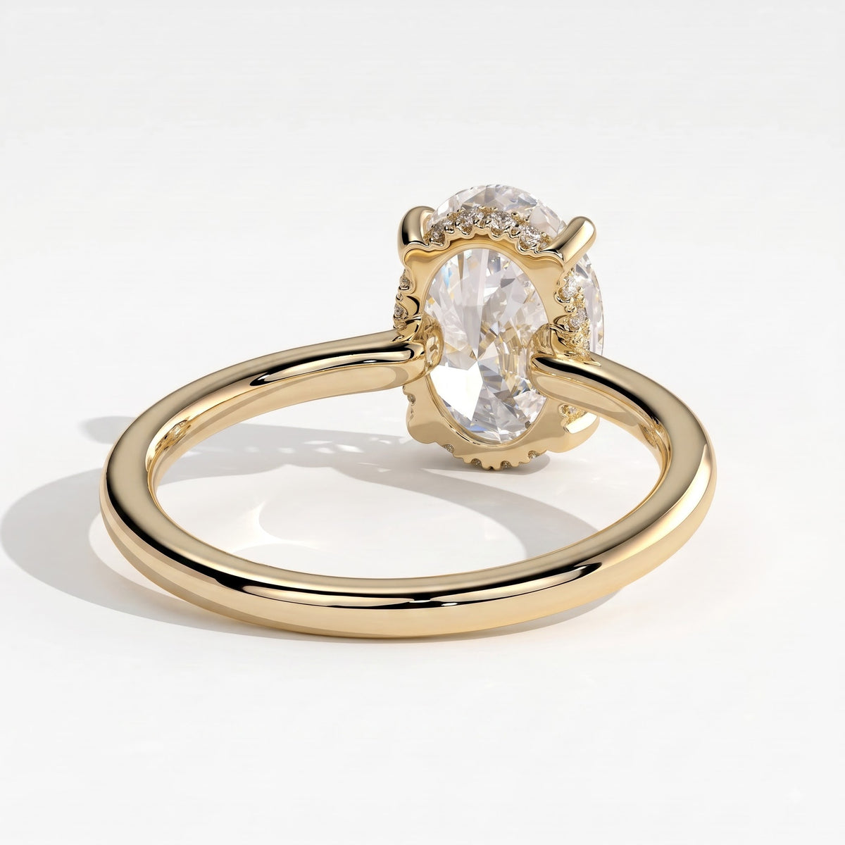 Oval lab-grown diamond solitaire engagement ring in 18K (750) yellow gold, on white background 