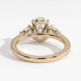Oval lab-grown diamond three-stone engagement ring in 14K (585) yellow gold, on white background 