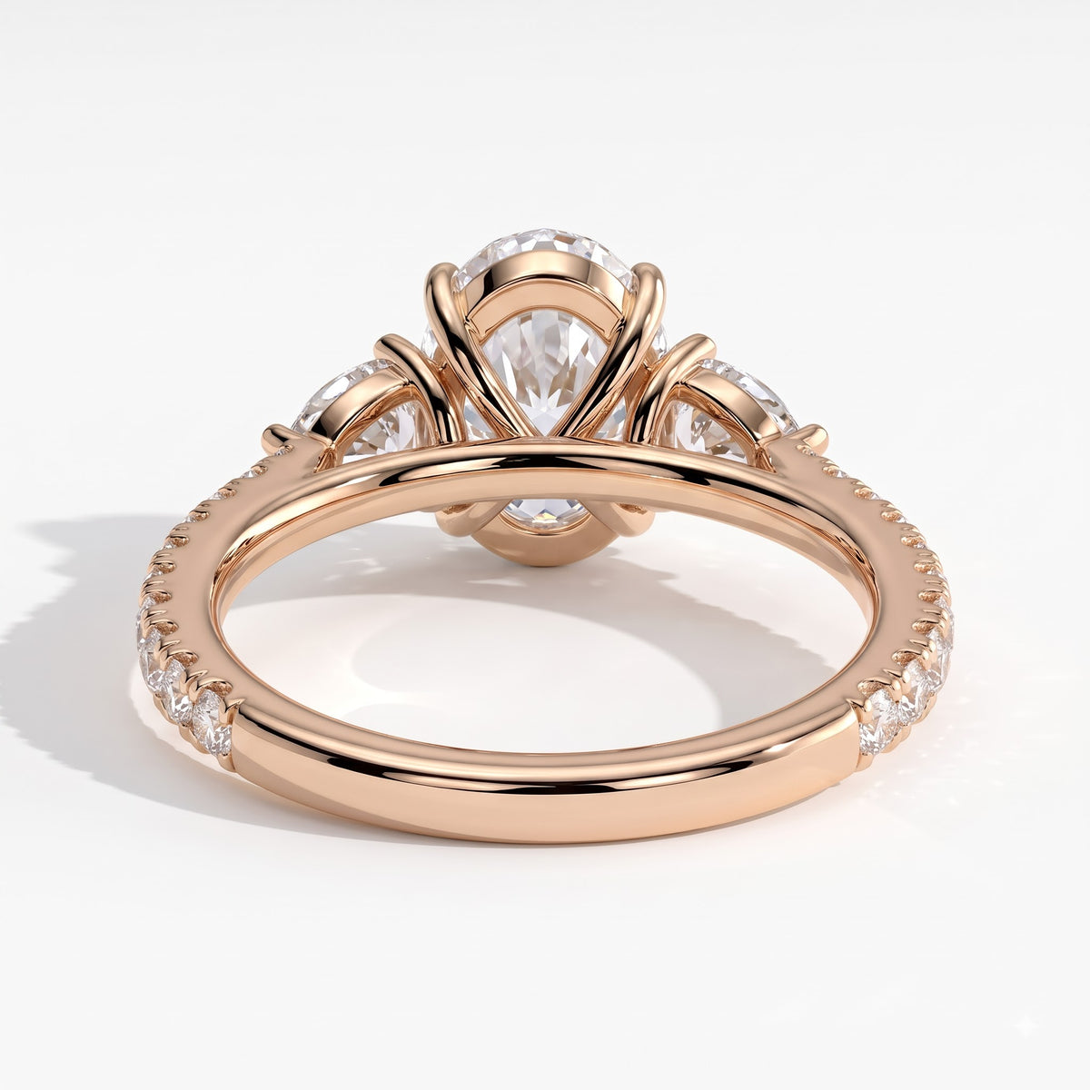 Oval lab-grown diamond three-stone engagement ring in 18K (750) rose gold, on white background 