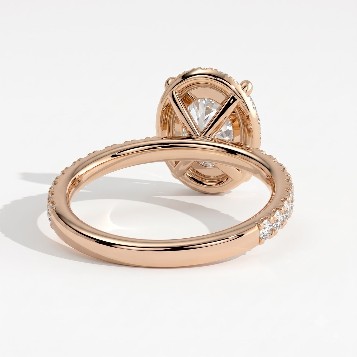 Oval lab-grown diamond halo engagement ring in 14K (585) rose gold, on white background 