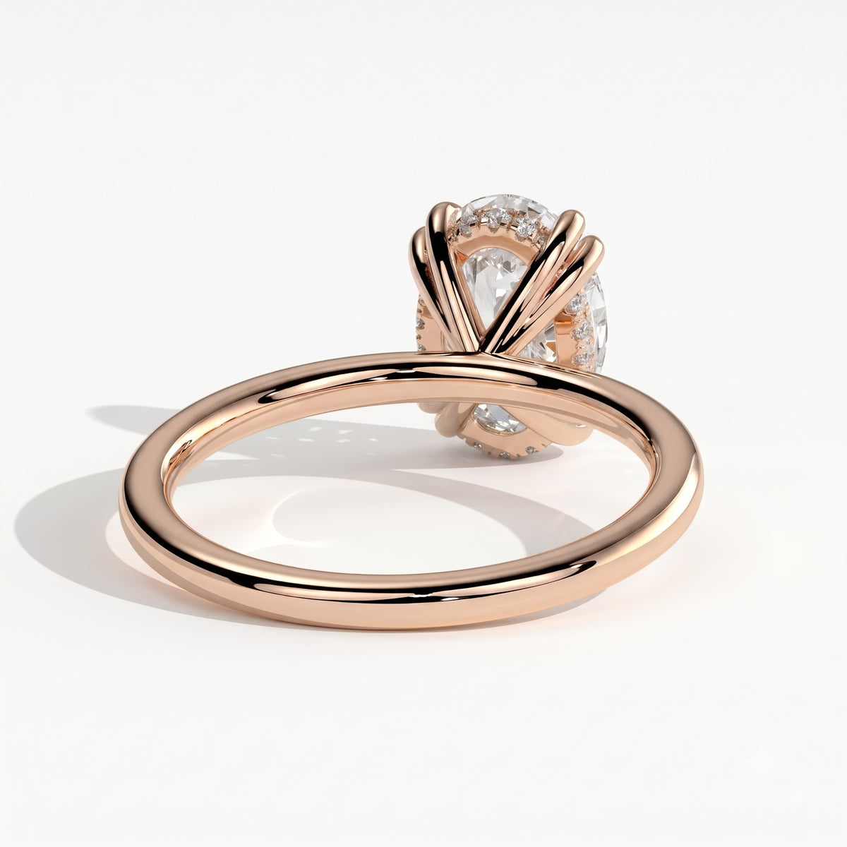 Oval lab-grown diamond halo engagement ring in 18K (750) rose gold, on white background 