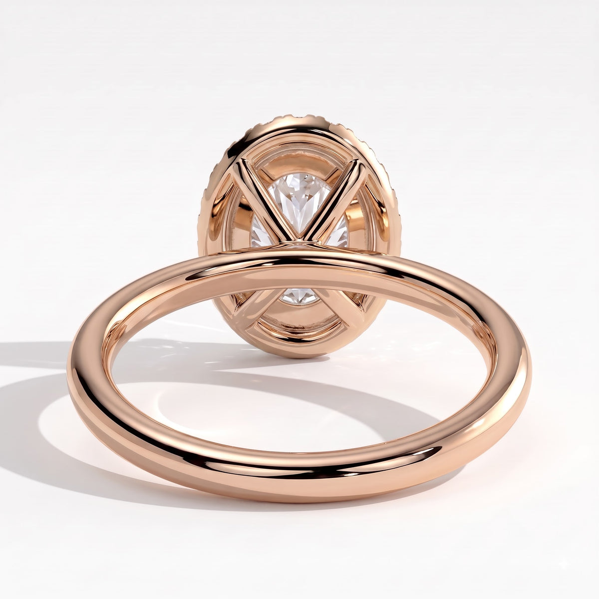 Oval lab-grown diamond halo engagement ring in 14K (585) rose gold, on white background 