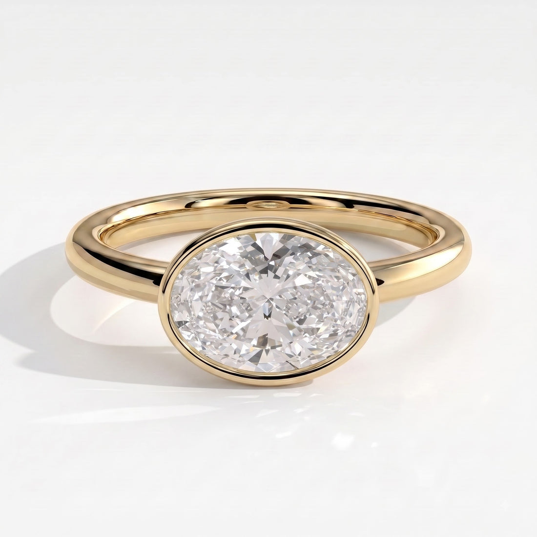 Oval lab-grown diamond bezel-set east-west solitaire engagement ring in 14K (585) yellow gold, front view 