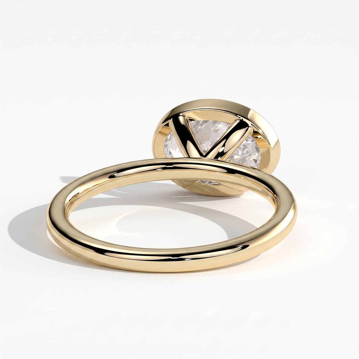 Oval lab-grown diamond bezel-set east-west solitaire engagement ring in 14K (585) yellow gold, on white background 