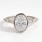 Oval lab-grown diamond bezel-set halo engagement ring in 950 platinum, front view 