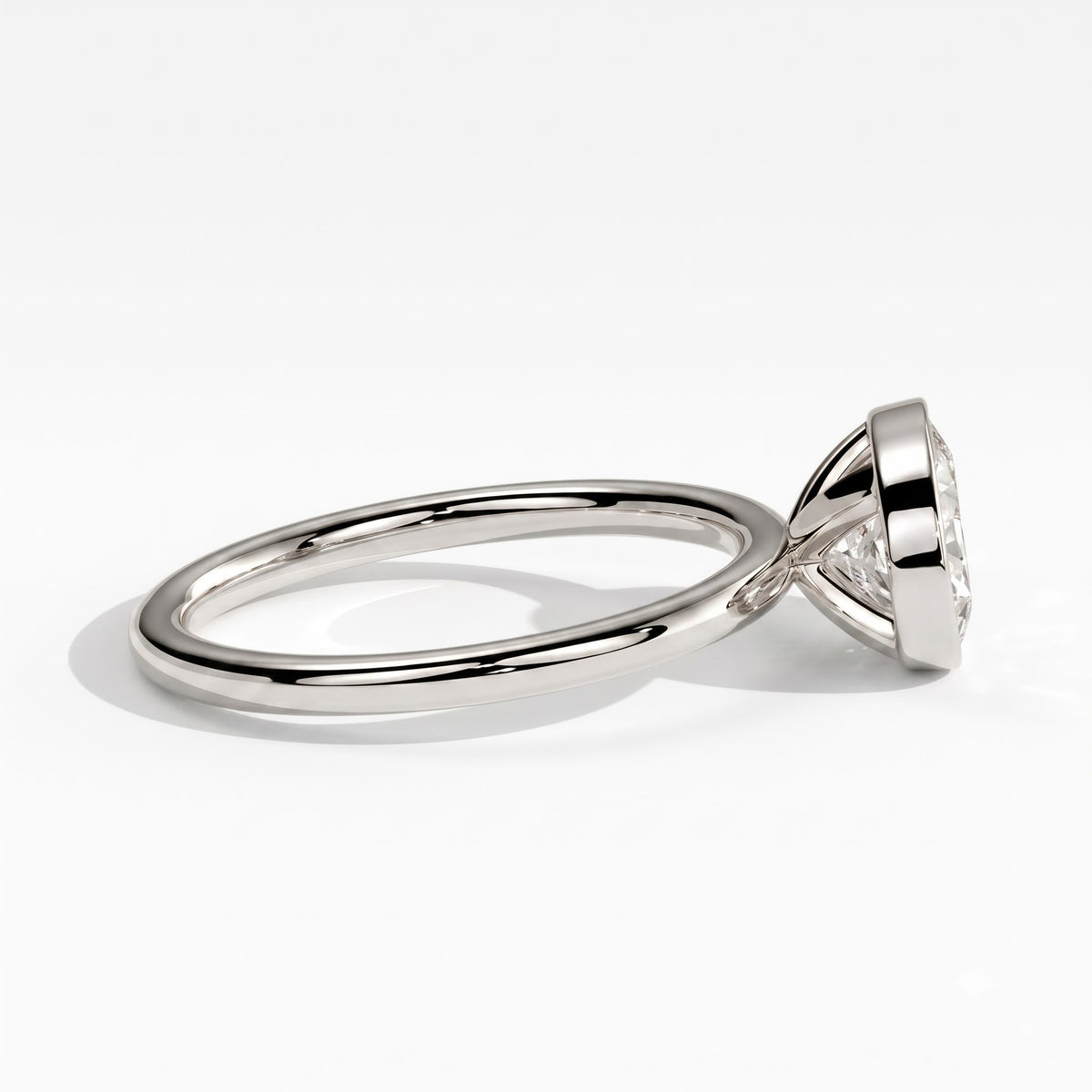 Oval lab-grown diamond bezel-set east-west solitaire engagement ring in 18K (750) white gold, detail view 