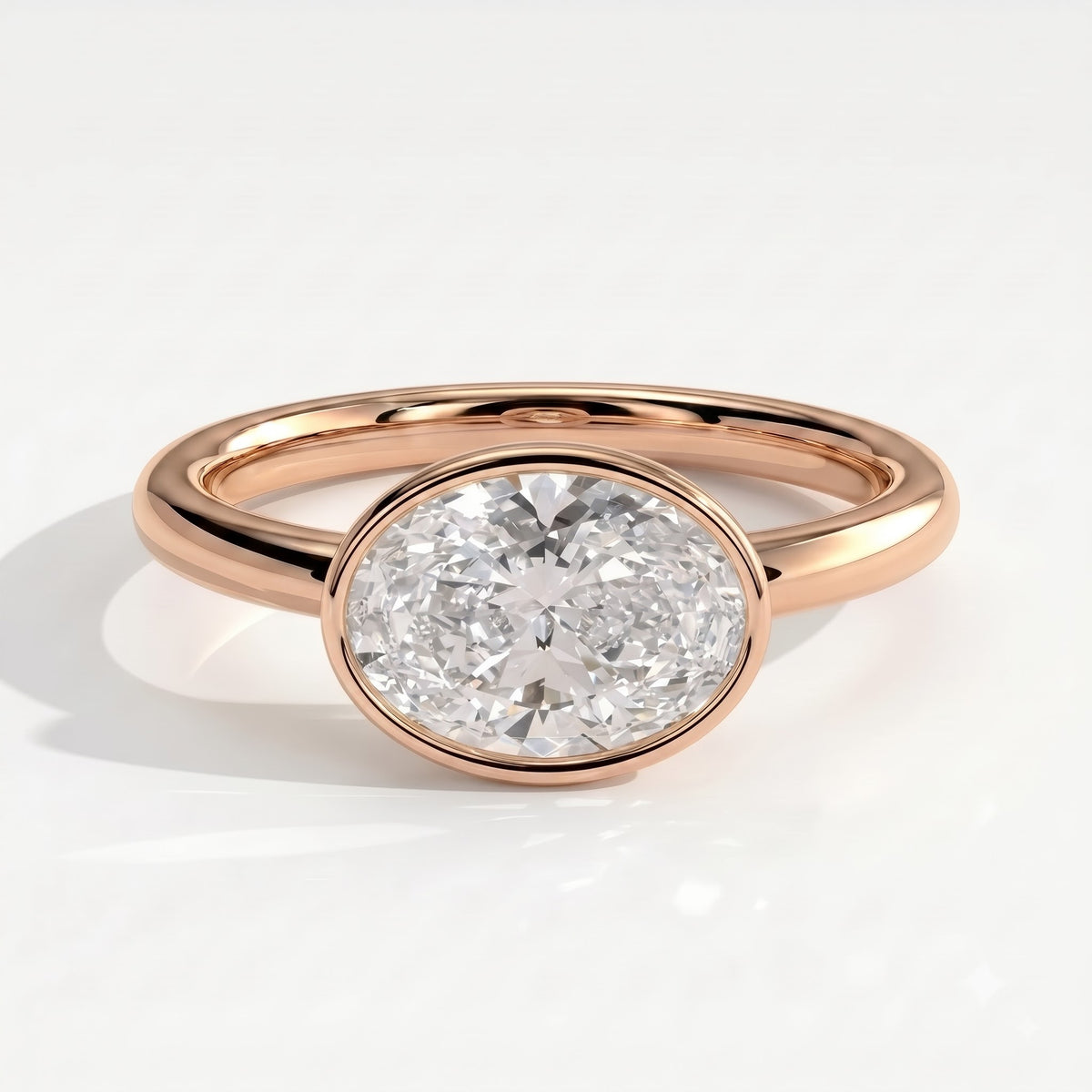 Oval lab-grown diamond bezel-set east-west solitaire engagement ring in 18K (750) rose gold, front view 