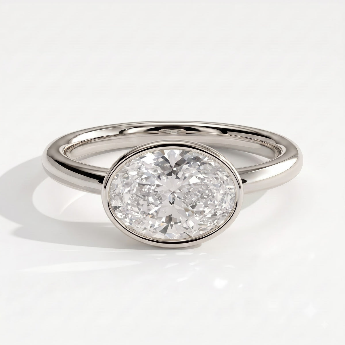 Oval lab-grown diamond bezel-set east-west solitaire engagement ring in 950 platinum, front view 