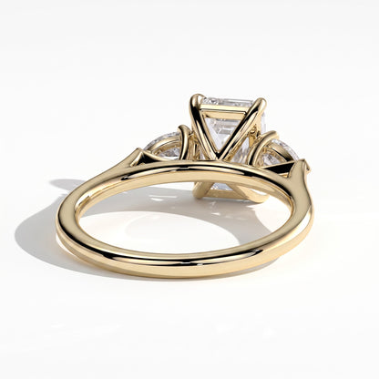 Emerald lab-grown diamond three-stone engagement ring in 14K (585) yellow gold, on white background 