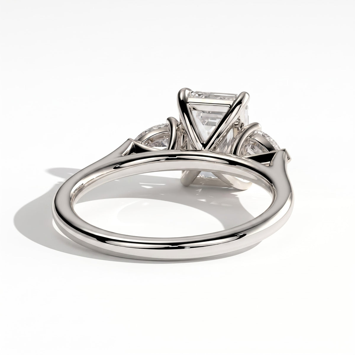 Emerald lab-grown diamond three-stone engagement ring in 950 platinum, on white background 